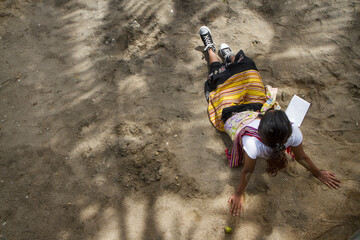 Obraz premium women wearing traditional ethnic fabric sitting on sand
