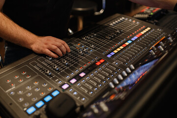 mixing console, a lot of faders and buttons. sound engineer hand