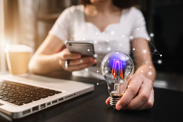 Female businessman entrepreneurs show creative business strategies with light bulbs as a concept. on the desk in the morning.
