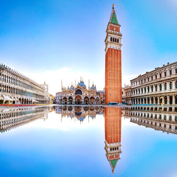 Sunrise in San Marco square with Campanile and San Marco's Basilica. Panorama of the main square of the Old town. Venice, Veneto, Italy. Reflection on the flooded square.