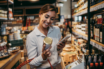Beautiful young and elegant woman buying some healthy food and drink in modern supermarket or grocery store. Lifestyle and consumerism concept.