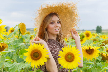 Fototapeta na wymiar Portrait of a pretty girl in a field of sunflowers.