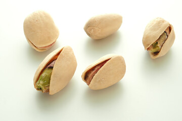 Pistachio nuts on a white surface.