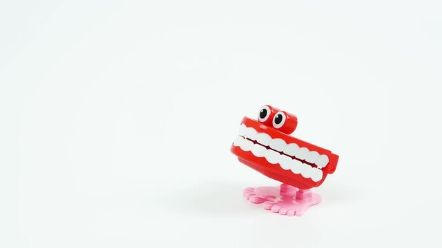 Chattering teeth toy stops on the side, white background