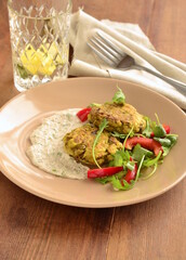 Lentil fritters with zucchini. Served with fresh vegetables and sauce, vertical