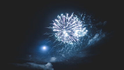 Feuerwerk während einer Feier im Nachthimmel einer Vollmondnacht. 