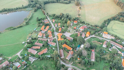 Aerial view of a small village.Top view of traditional housing estate in Czech. Looking straight down with a satellite image style.Houses from above, real estate concept.Country road urban scene