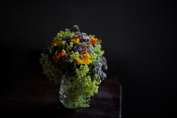 Käuter-strauss, Blumenstrauß mit Heilkräutern und Kräutern vor dunkelem Hintergrund vom Floristen