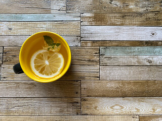 yellow cup with lemon on a wooden background