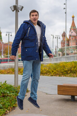 portrait of a handsome young man шт jump against the Kremlin in Moscow