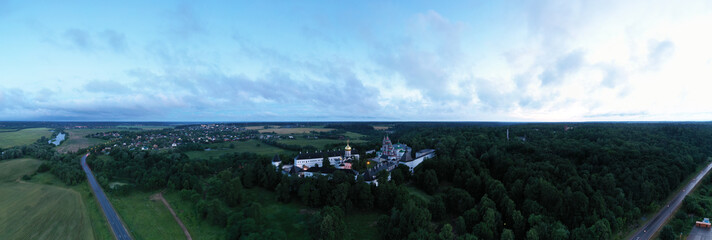 white stone fortress at dawn on a green hill filmed from a drone