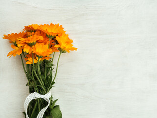 Beautiful, bright wildflowers lying on a white, wooden table. View from above, close-up