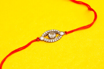 Close up portrait isolated colourful rakhi with yellow background