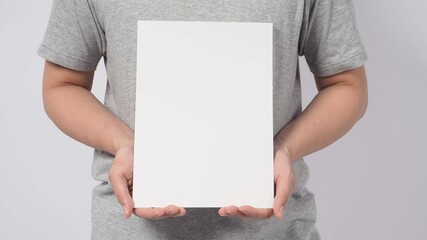 Male model's hands is holding the A4 paper and wear gray t shirt on white background.