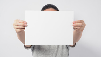 Fototapeta premium Male model's hands is holding the A4 paper and wear gray t shirt on white background.