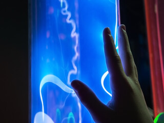 Close-up photo of a hand reaching for a flask with electric discharges inside