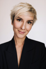 Blonde girl in a pantsuit in the studio on a white background