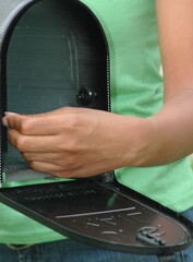 African american female at her mailbox outside.