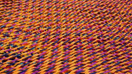 Yellow, dark blue and purple knitted cloth suface. Fiber material for handcraft knitting. Thread in form of net or web