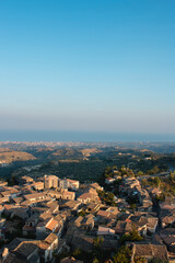 Obraz premium aerial view of Gerace, Calabria (Italy) at the sunset on a hill. A south italian village. it is possible see the stone houses and the wood around them. 