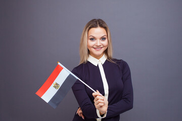 Immigration and the study of foreign languages, concept. A young smiling woman with a Egypt flag in her hand.