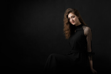 Fototapeta premium Studio portrait of a beautiful girl on a black background