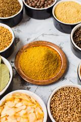 Diverse seasoning in ceramic bowls, closeup on white surface