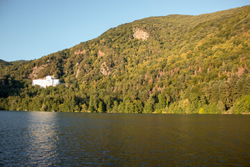 Obraz premium skyline of Monticchio lake in the sunset. It is an amazing lake with church near them. The lake is in a wonderful forest with a lot of trees on the hills with a white church