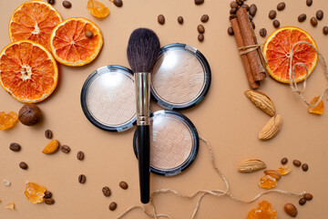 Cosmetics for natural makeup, highlighter powder and toner, fluffy makeup brush on top.