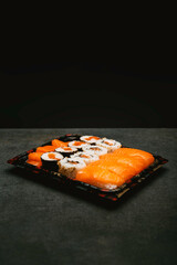 stock photography assorted rice sushi inside three tupper black reusable tray on gray background