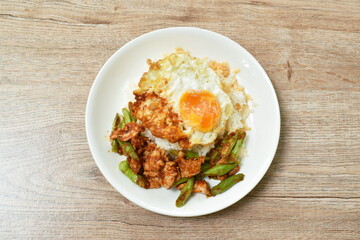 spicy fried pork with slice yard long bean in curry on rice topping egg