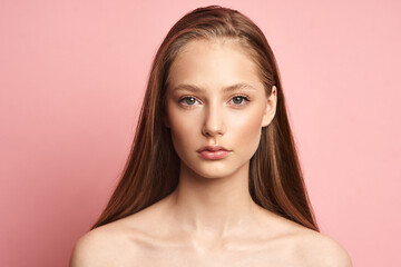 Beauty makeup. Portrait of a young girl with natural make-up on a pink background