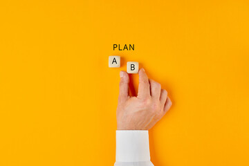 Hand of a businessman choosing business plan b out of two options - obrazy, fototapety, plakaty