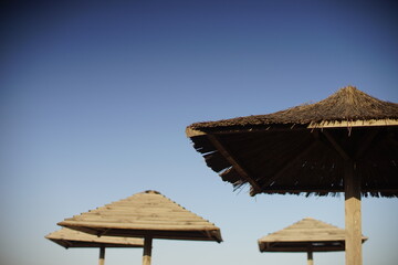 straw canopies against the blue sky.