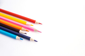 Colored pencils on a white background. Variety of colors. School supplies.