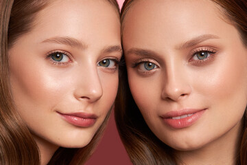 Beauty. Smiling girls with perfect face skin and natural portrait make-up. Beautiful model close-up on a pink background.