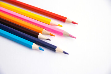 Colored pencils on a white background. Variety of colors. School supplies.