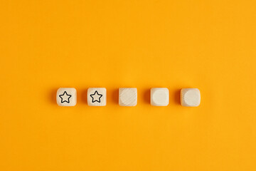 Wooden cubes with two stars out of five. Concept of poor service rating and evaluation.