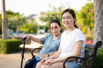 Obraz premium Granddaughter pointing her forefinger to the skies and let her grandmother take a look. Happy relationship in the Asian family. Caring for elder people in family after retirement.