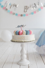 One-year-old children's cake decorated with pink and blue macaroons with number one topper on a white background. Beautiful birthday cake for a child. - 362163028