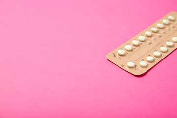 Female oral contraceptives on a pink background.Place for text