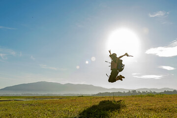 Young woman travel and explore adventure pointing  in nature. Asian people jumping relax for destination leisure landscape forest in summer day. 