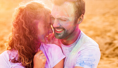 Optimistic couple with colorful faces on beach