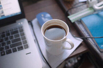 Workspace desk with notebook and cup of coffee on it