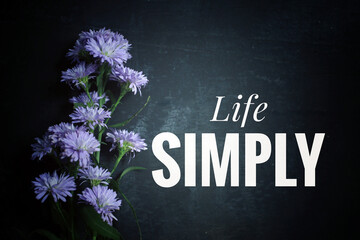 Inspirational quote - Life simply. Text message written on blackboard with blue purple flowers...