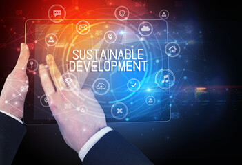 Close-up of a tablet with SUSTAINABLE DEVELOPMENT inscription, innovative technology concept