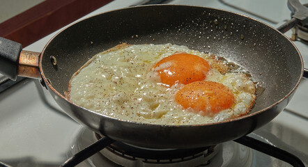 Adding  black pepper to the simple fried eggs    