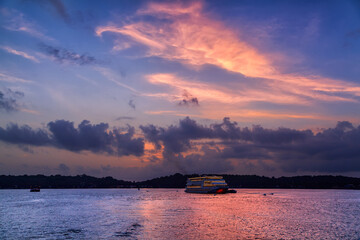 Small cruise boat with beautiful sunset at Goa, India. - obrazy, fototapety, plakaty