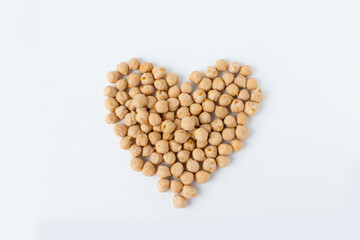 Pile of chickpeas on white background. Garbanzo beans traditional Near Easten food. Heart shape.