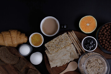 Beautiful view of a colorful breakfast table with beautiful decorations along with delicious dessert cakes with a black background.